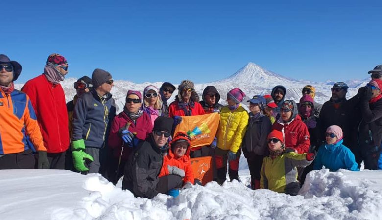 تیم باشگاه کوهنوردی سرکچال بر فراز قله ریزان با نمای زیبایی از دماوند باشکوه در پشت صحنه